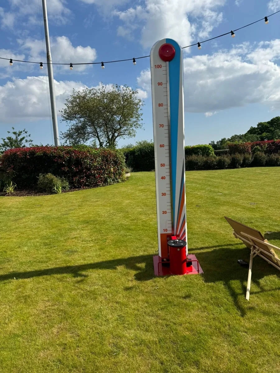 Traditional high striker set up on a lawn at a garden party